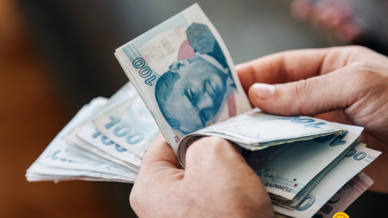 elindeki para destesini sayan bir kişi